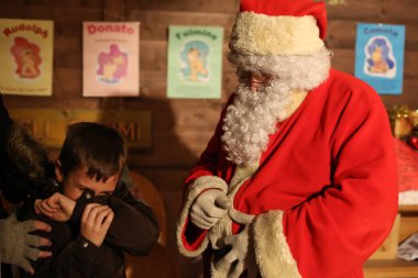 Torino, İtalya - 01.06.2014: Küçük utangaç çocuk Noel Baba 'ya Noel dileklerini söylemek ve bayram hediyesi almak için geldi