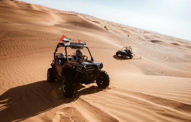 Dubai, BAE - 12.13.2014: Emirlik bayrakları, lüks turist eğlencesi, motorlu taşıt maceraları ile Al Awir kum tepelerinde iki at arabası gezintisi   