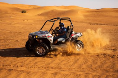 Dubai, BAE - 12.13.2014: Erkek sürücü sürüş ve sürüş arabası, Al Awir kasabasındaki çöl kum tepelerinde dörtlü bisiklet, ekstrem motor sporları 