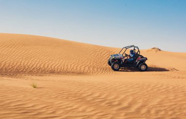 Dubai, BAE - 12.13.2014: Al awir safari turunun çöl kum tepelerinde at arabası süren turist gurubu
