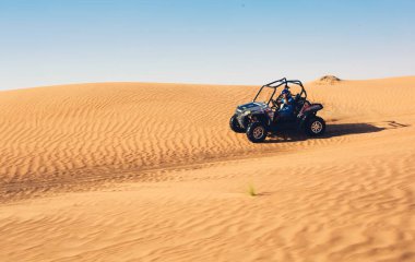 Dubai, BAE - 12.13.2014: Kum tepesinden çöl safari turuna giden kasklı dört tekerlekli bisiklet sürücüsü 