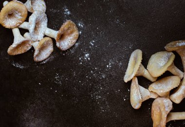 Koyu gri masa arkaplanı, şeker tozu ve mantar şeklinde kurabiyeler, yaratıcı hamur işi.