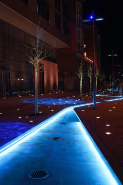 Dnipro, Ukrayna - 04.02.2021: Dnipropetrovsk şehir merkezi, Yuzhnaya sokağı gece aydınlatması açık mavi dereli, modern mimari fikirleri