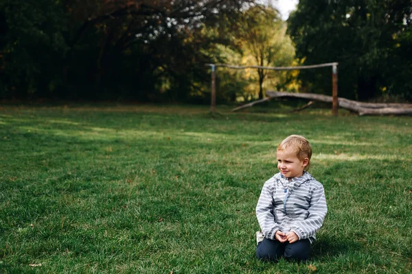 Malý Zlobivý Chlapec Úsměv Sedět Zelené Louce Aktivní Šťastný Dětství — Stock fotografie