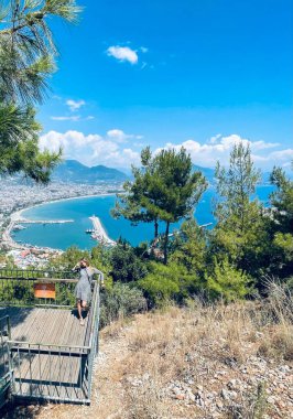 Kız Alanya, Türkiye 'de deniz, dağ ve şehir arkaplanlı manzaralı bir yerde kalıyor