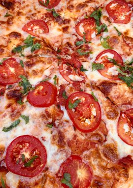 Pizza Margherita arka planı erimiş peynir, domates ve maydanozla yakın plan