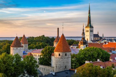 Tallinn 'in Eski Şehir' inin günbatımında yükseltilmiş panoramik görüntüsü, ortaçağ savunma kuleleri, kırmızı kiremitli çatıları ve Baltık Denizi kuleleri ile birlikte