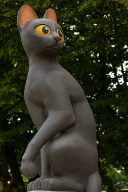 RIGA, LATVIA - 11 Temmuz 2025: Sarı gözlü bir kara kedi heykelinin yakın çekimi, Riga 'nın meydan okumasının gayri resmi sembolü haline gelen kedi imajının oyuncu bir temsili