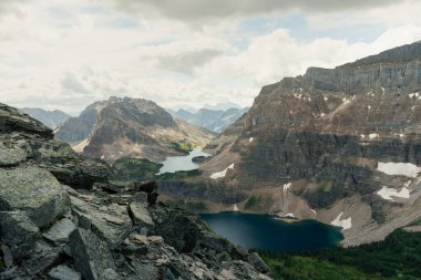 Mountain Vista: Rugged peaks overlook serene lakes under a cloudy sky.