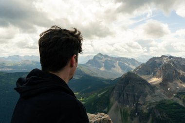 Man Overlooking Vast Mountain Range in Cloudscape View Scenic Perspective