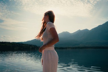 Kadın doğayı düşünüyor, uzaktaki dağların göl manzarasını. Piramit Gölü, Jasper, AB