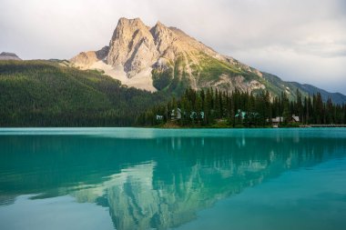 Zümrüt göl, dağları, ağaçları ve sakin manzaralı evleri yansıtır. Zümrüt Gölü, BC