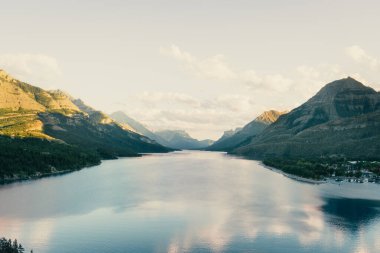 Sakin göl manzarası güzel, açık bir günde dağların arasına yerleşmiş. Waterton, AB