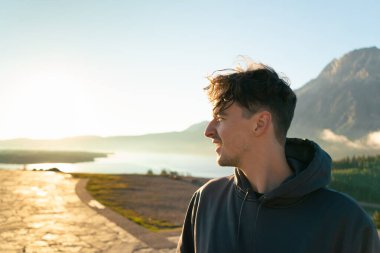Güneş doğarken manzaraya bakan bir adam güzelliğini takdir eder. Waterton, AB