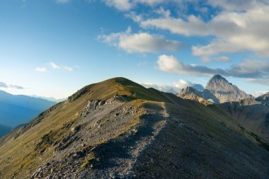Engebeli, kayalık bir dağın yamaç çizgisi boyunca kıvrılan bir patika. Çadır Sırtı, Kananaskis, AB