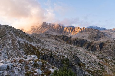 Resimli dağ sırası batan güneşin sıcacık parıltısıyla yıkandı. Buzul Ulusal Parkı, BC