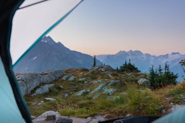 Dağ sırasının sabah manzarası doğadaki kamp çadırının içinden. Buzul Ulusal Parkı, BC