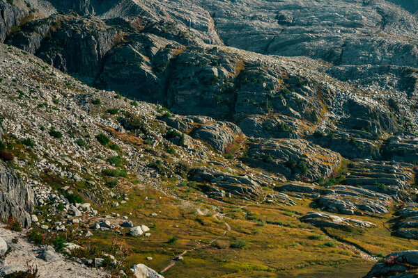 Rugged mountain landscape with grass, rock formations. Glacier National Park, BC