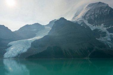 Turkuaz suları ve buzul oluşumlarıyla sakin dağ manzarası. Berg Gölü, BC