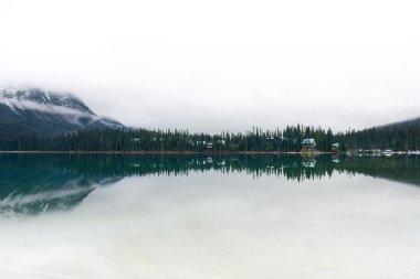 Sakin bir göl manzarası. Orman ve dağ sakin suları yansıtıyor. Zümrüt Gölü, BC