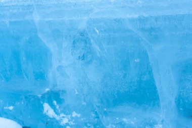 Kırık mavi buza yakın plan soğuk ve donmuş bir manzara sergiliyor. Kış arkaplanı, doku örtüsü veya soğukluk ve kırılganlığı temsil etmek için kullanışlıdır