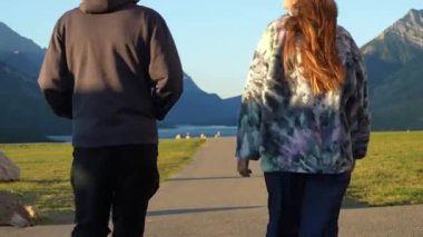 İki birey güzel bir dağ gölüne doğru yürür. Ortam huzurlu ve maceraperest. Waterton, AB, Kanada