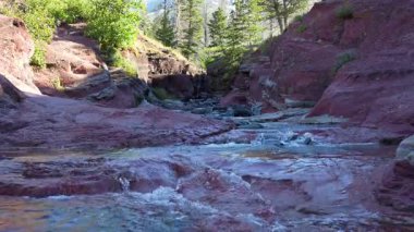 Temiz su, güzel ve doğal bir kanyonda kızıl kaya oluşumlarının üzerinden akar. Sakin, doğal ortam. Waterton, AB, Kanada