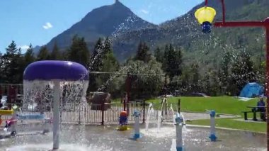 Su özellikli parlak sıçrama rampası, yüksek bir dağ arka planı ve yemyeşil ağaçlar. Neşeli, serin bir yaz. Waterton, AB, Kanada