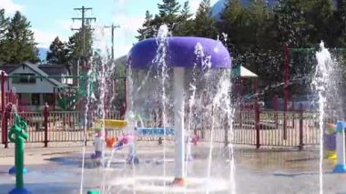 Su özellikli parlak bir sıçrama tahtası. Çeşmeler su püskürtür. Neşeli, ferahlatıcı ve canlı bir yaz sahnesi. Waterton, AB, Kanada