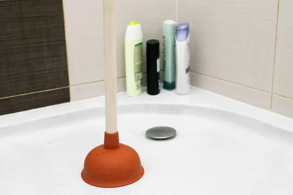 The main subject is out of focus, Solving Common Household Drain Problems, symptoms Solutions blockage plumbing bathroom unclog plunger force cup male man hand hold