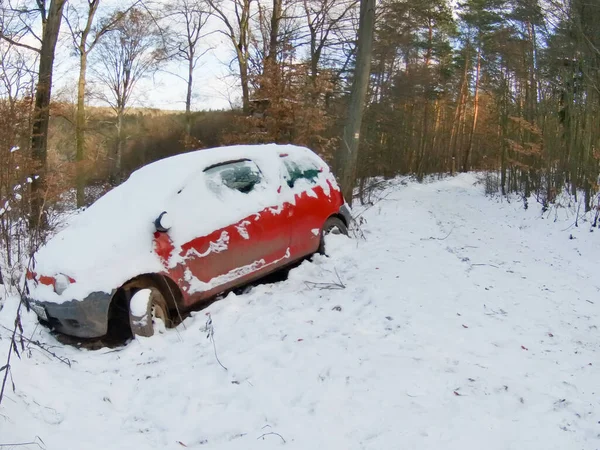 Karda terk edilmiş kırmızı araba ormanı kaza yapmış..
