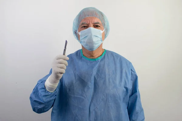 old senior male surgeon stand white background uniform doctor health care emergency profession help people hand hold scalpel medical gloves surgical hair net man