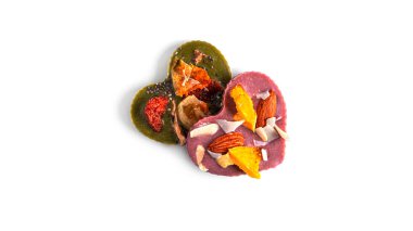 Çiğ kalp şeklinde çikolata, kurumuş meyve ve fındıklı beyaz arka plan. Yüksek kalite fotoğraf