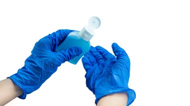 Beyaz arka planda antiseptik bulunan mavi eldivenli eller. Yüksek kalite fotoğraf