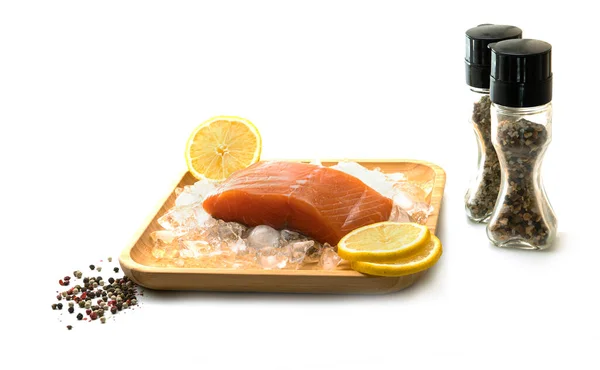 一片新鲜的鲑鱼 冰柠檬在白色背景的木制正方形盘子里 盐和香料 高质量的照片 — 图库照片