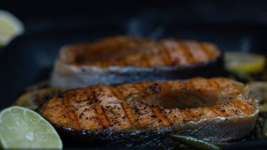 Baharatlı ızgara somon ve koyu arkaplanda limon suyu. Yüksek kalite fotoğraf