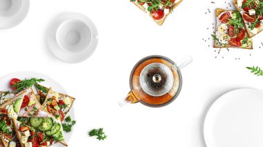 Lezzetli ve güzel atıştırmalıklar. Farklı dolgulu sandviçler ve çay. Beyaz bir arka planda izole edilmiş. Yüksek kalite fotoğraf