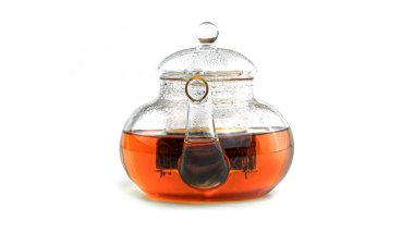 Beyaz zemin üzerinde çay olan şeffaf çaydanlık. Yüksek kalite fotoğraf