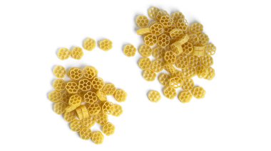 Beyaz arka planda izole edilmiş cam kavanozdaki Rotelle makarnası.