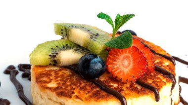 Beyaz arka planda çikolatalı ve meyveli cheesecake..