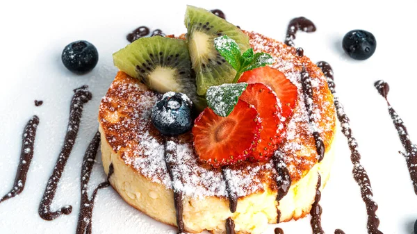 Beyaz arka planda çikolatalı ve meyveli cheesecake..