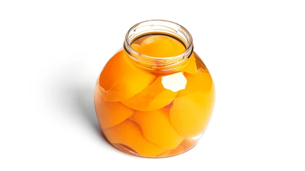 Pêssegos enlatados em frasco de vidro. Pêssegos doces em xarope isolado no fundo branco. Imagem De Stock