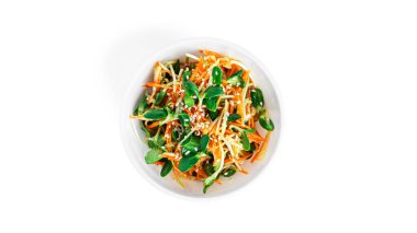 Beyaz arka planda izole edilmiş havuçlu ve salatalıklı mikroyeşil salata..