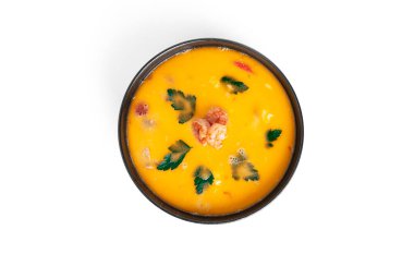 Beyaz arka planda izole edilmiş siyah bir tabakta karidesli çorba. Deniz mahsullü Tayland çorbası. Thai tom yum çorbası