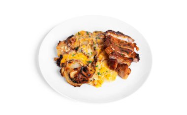 Beyaz arka planda izole edilmiş, peynirli fırında patates ve domuz bifteği..