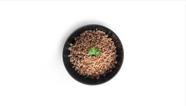 Karabuğday lapası siyah kasede, beyaz arka planda izole edilmiş..