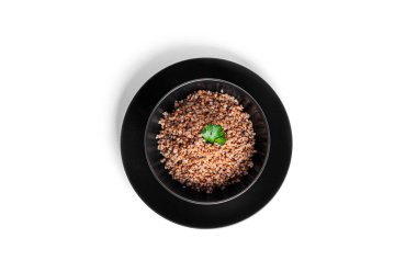 Karabuğday lapası siyah kasede, beyaz arka planda izole edilmiş..