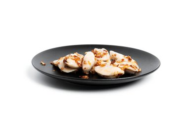 Beyaz arka planda izole edilmiş siyah tabakta patates ve kızarmış soğanlı hamur tatlısı..