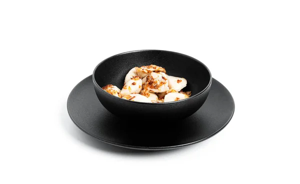 Knödel mit Kartoffeln und gebratenen Zwiebeln in schwarzem Teller isoliert auf weißem Hintergrund. — Stockfoto