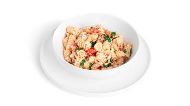 Beyaz arka planda bulunan peynirli makarna, domates ve otlar. Feta makarna.